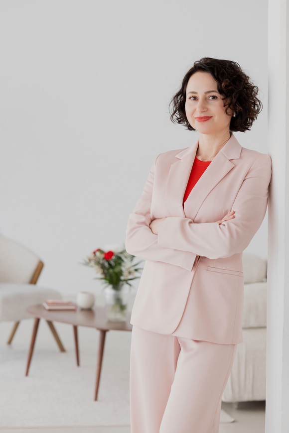 claudia-di-chio-herzschaetzerin-gesunde-arbeitskultur Herzschätzerin, Claudia di Chio Arme verschränkt und angelehnt an Wand